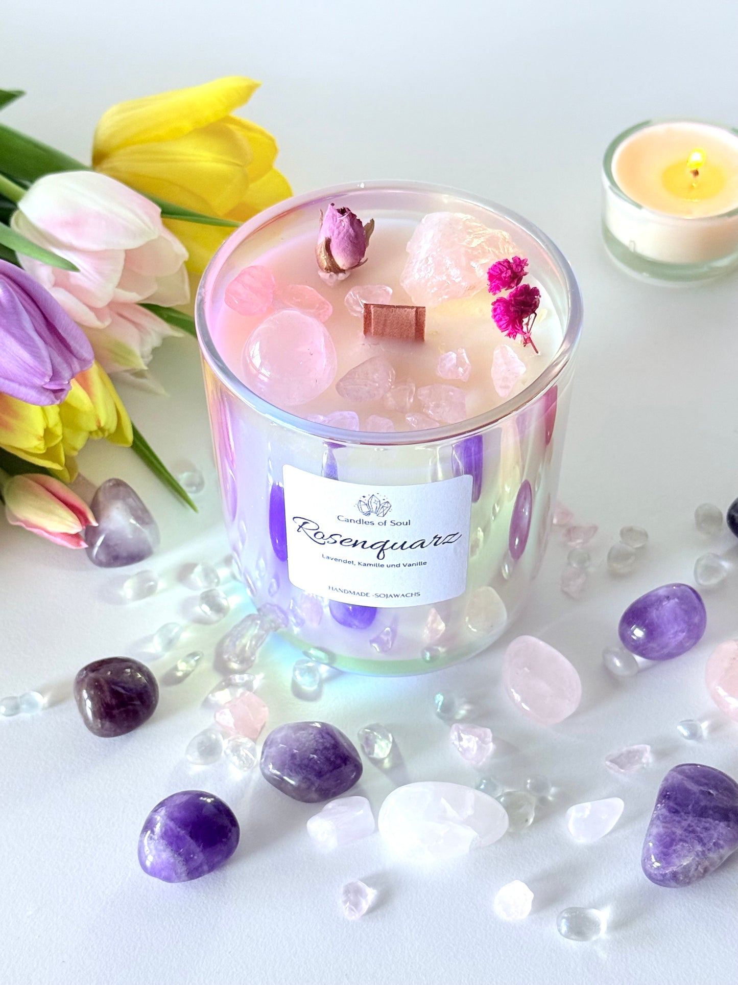 Sojawachskerze in schimmerndem Glas mit Rosenquarz und getrockneten Blüten, dekorativ arrangiert.