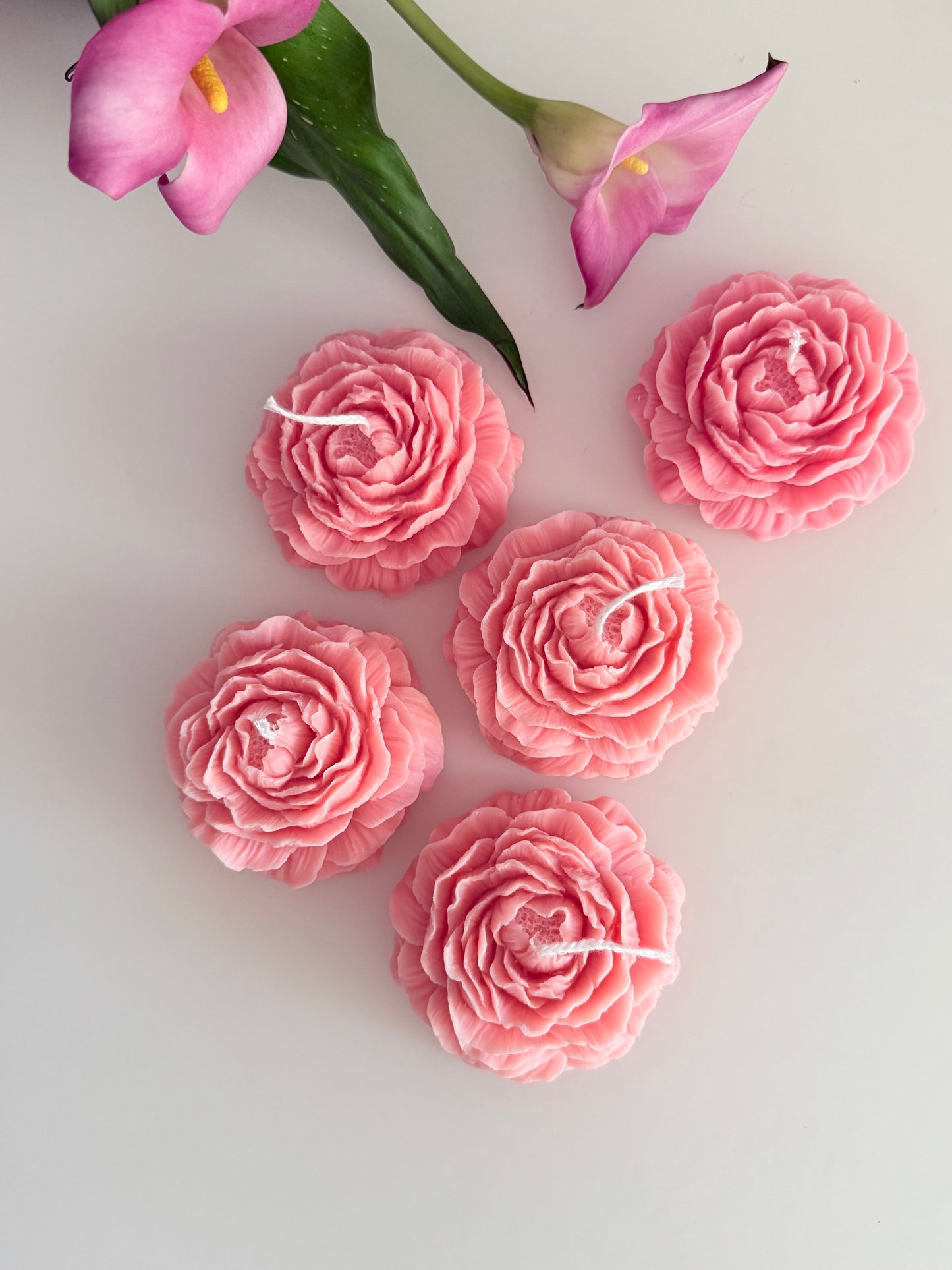 Detailaufnahme einer handgemachten Rosenblüten-Kerze aus rosa Wachs