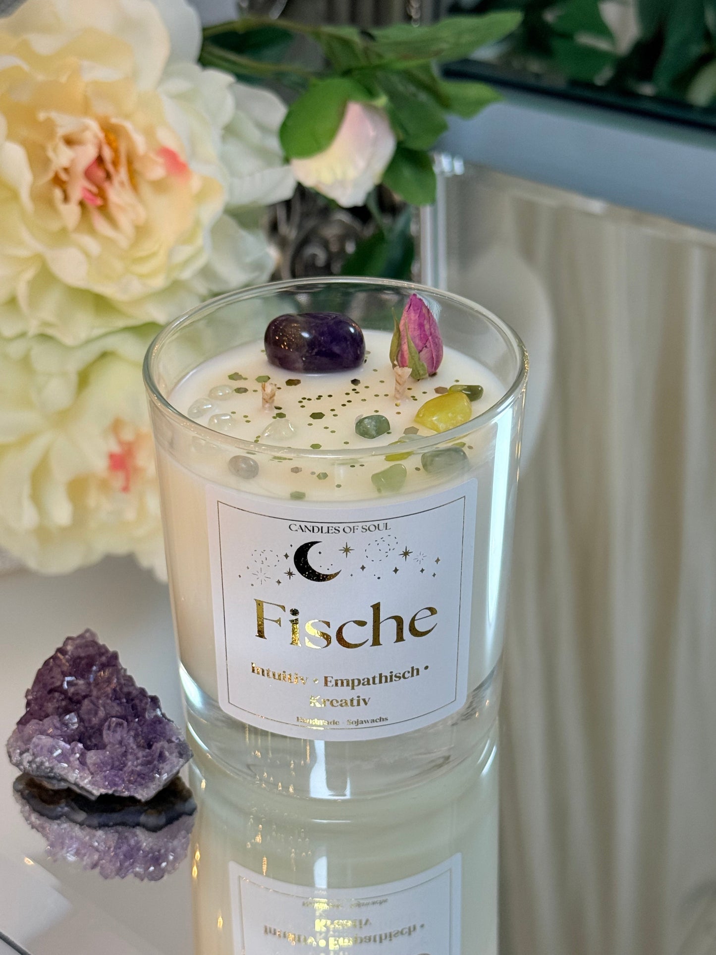 Spirituelle Dekoration mit Heilsteinen für das Sternzeichen Fische auf einer Spiegelfläche.