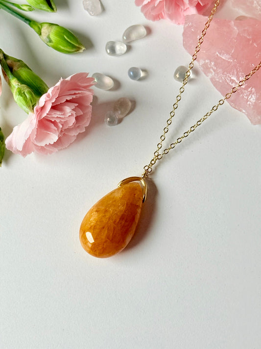 Tropfenförmiger Eisenquarz-Anhänger in Gelb-Orange an goldfarbener Kette, dekorativ mit Blumen und Edelsteinen arrangiert