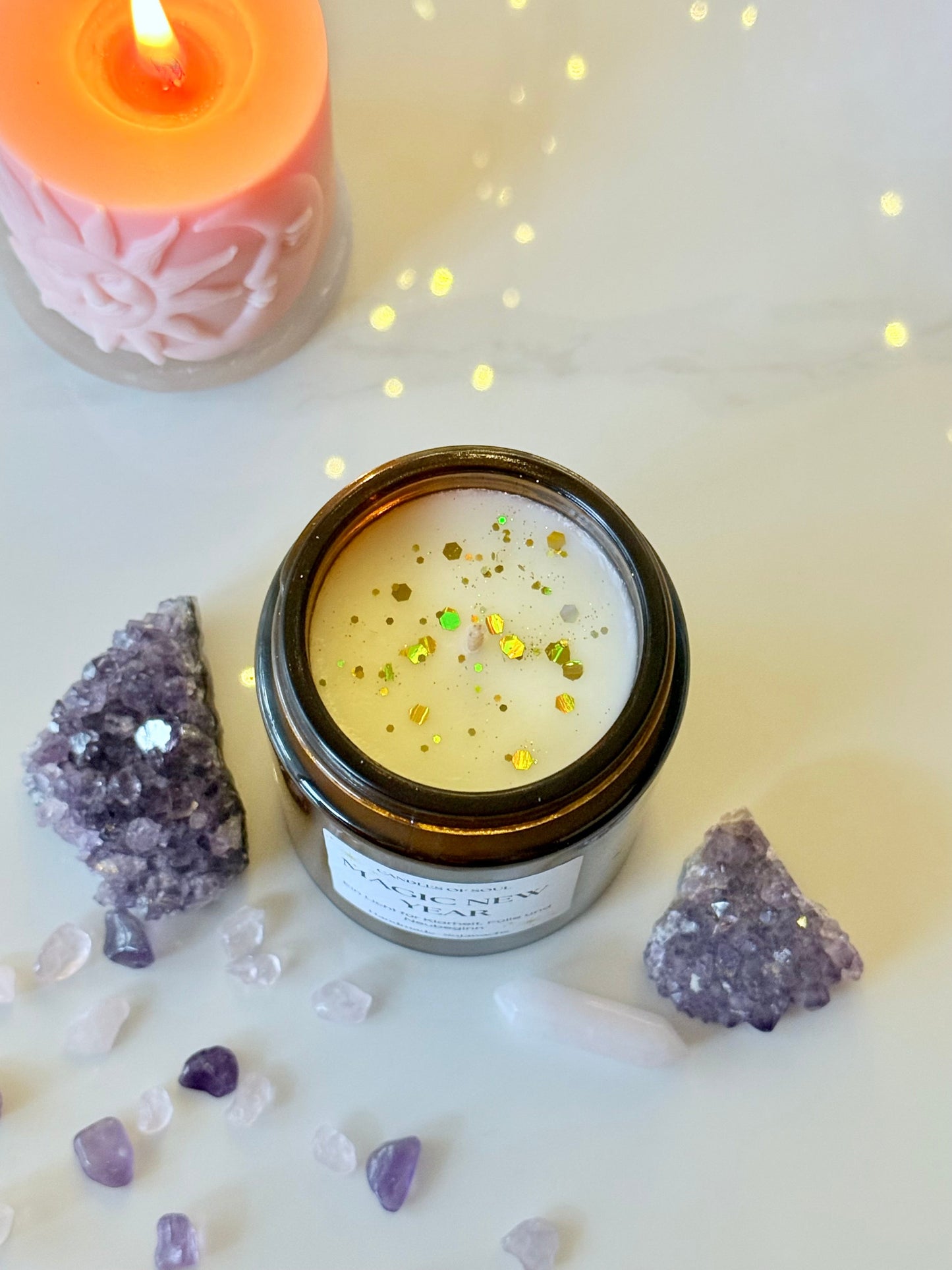 Handgemachte Kerze für Neubeginn vor winterlicher Lichterketten Deko und Kristallen.