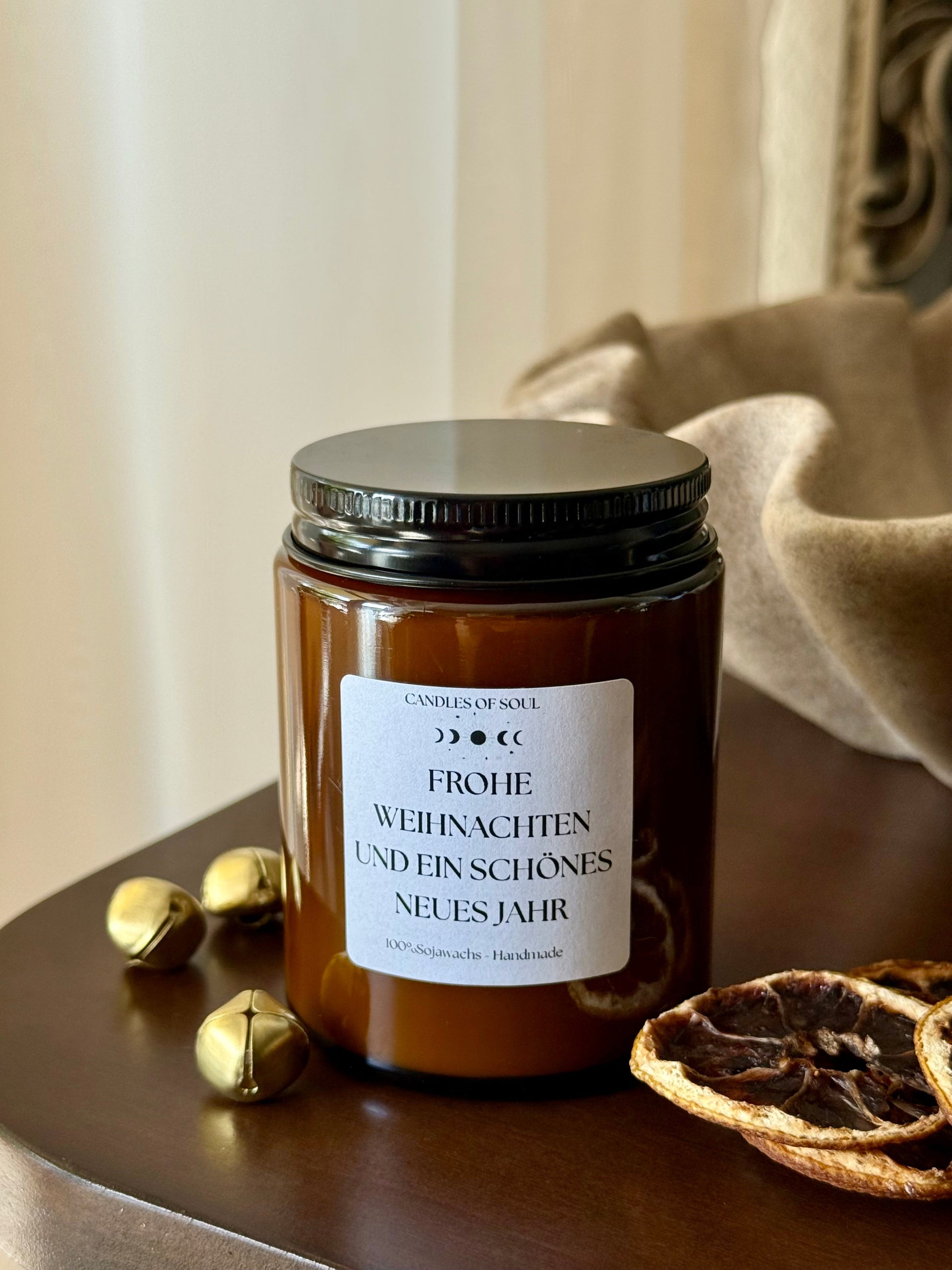 Brennende Weihnachtsduftkerze im Glas auf Holztisch – natürliche Dekoration