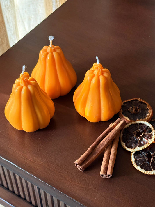 Handgemachte Kürbis-Kerze aus nachhaltigem Rapswachs in warmem Orange, perfekt als herbstliche Tischdekoration.