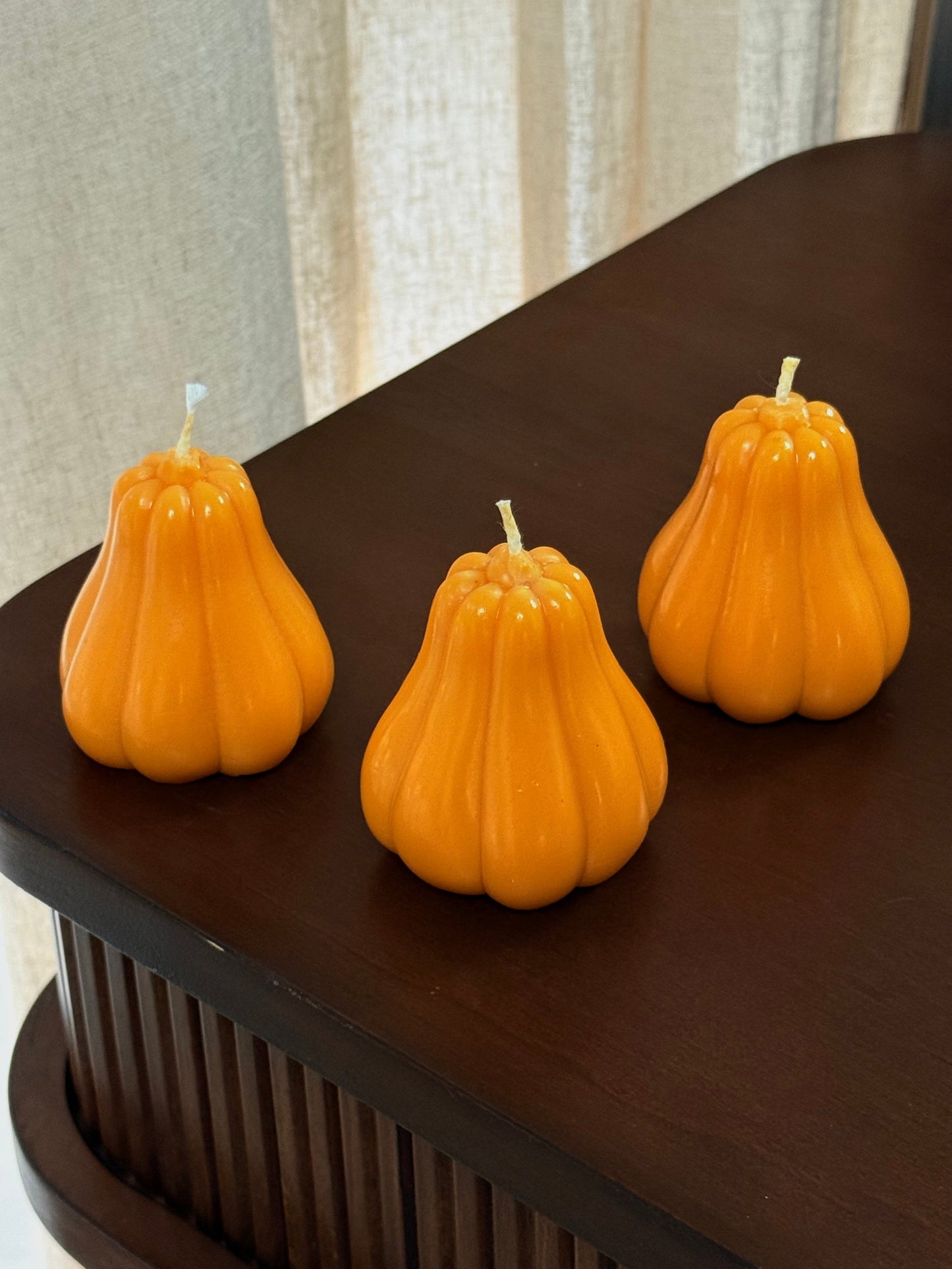 Dekorative Kürbis-Kerzen in verschiedenen Größen und Farben, stimmungsvolle Herbst- und Thanksgiving-Deko.