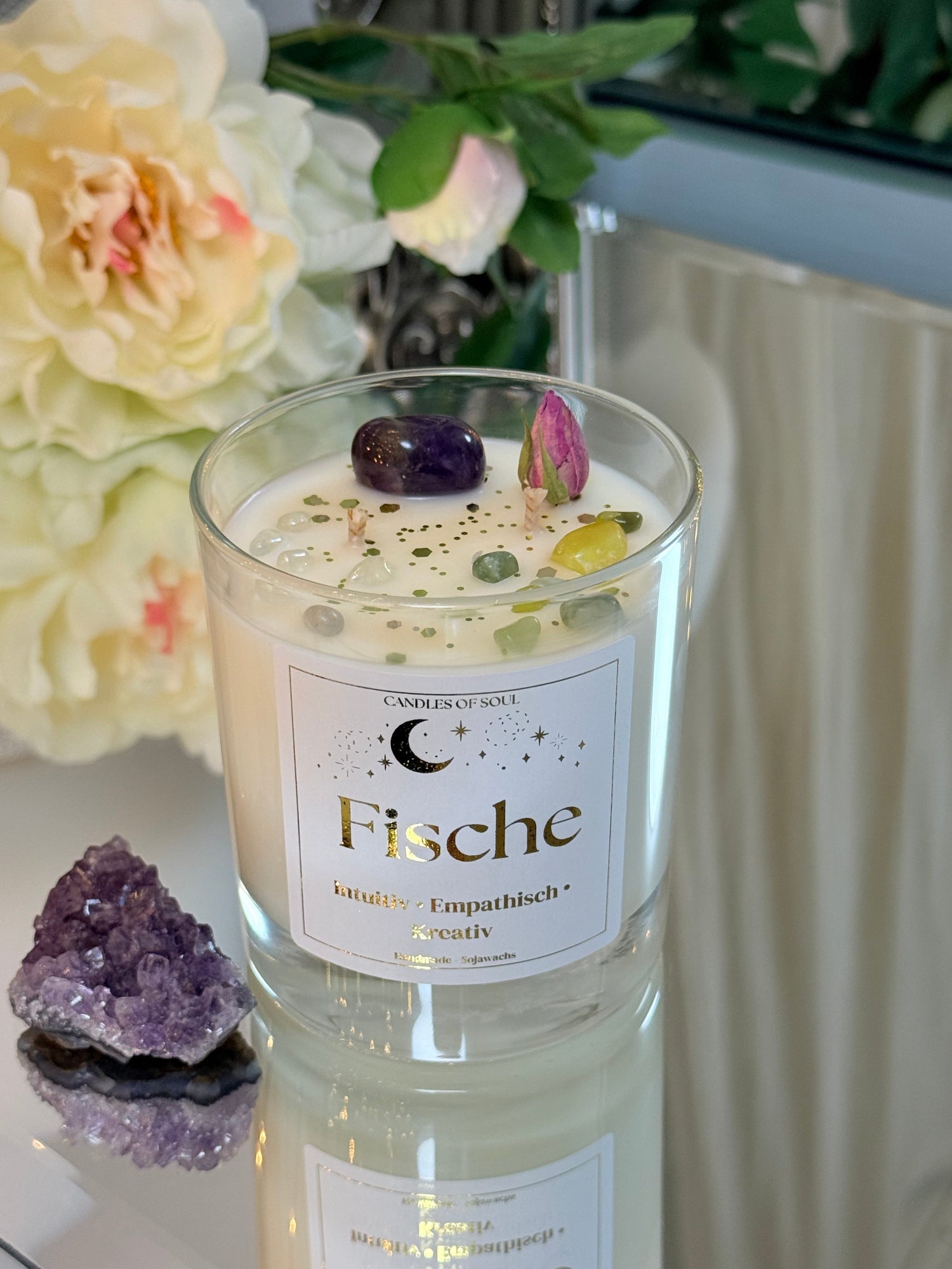 Spirituelle Dekoration mit Heilsteinen für das Sternzeichen Fische auf einer Spiegelfläche.