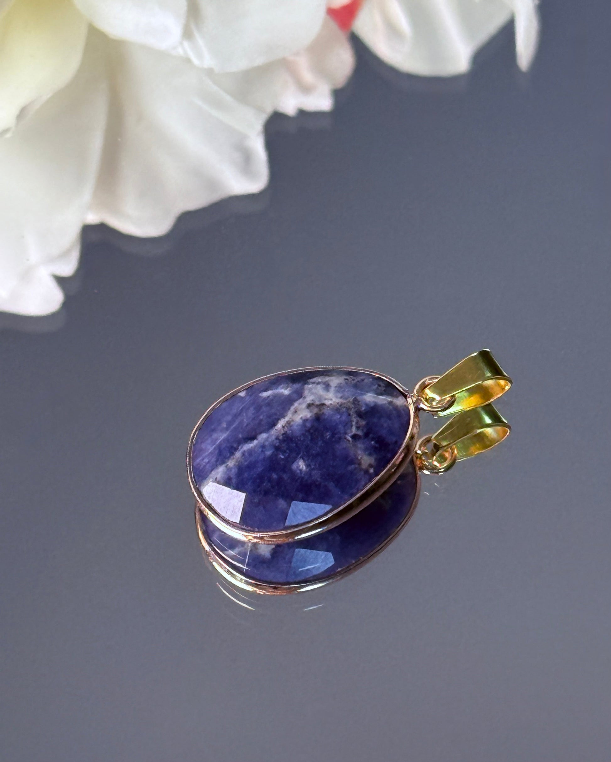 Detailaufnahme der goldenen Kupferfassung und der blauen Struktur des Sodalith Steins.