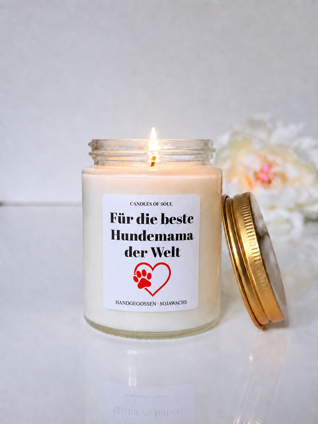 Detailaufnahme der Hundemama-Geschenkkerze mit rotem Pfotenherz und weißen Blumen
