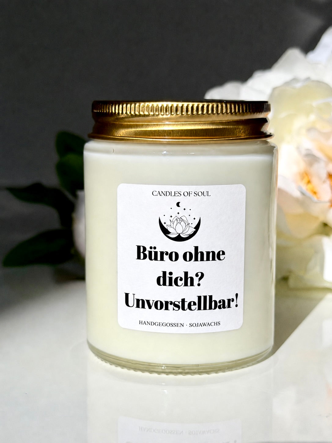 Weiße Sojawachs-Duftkerze mit goldenem Deckel und dem Spruch „Büro ohne dich? Unvorstellbar!“.