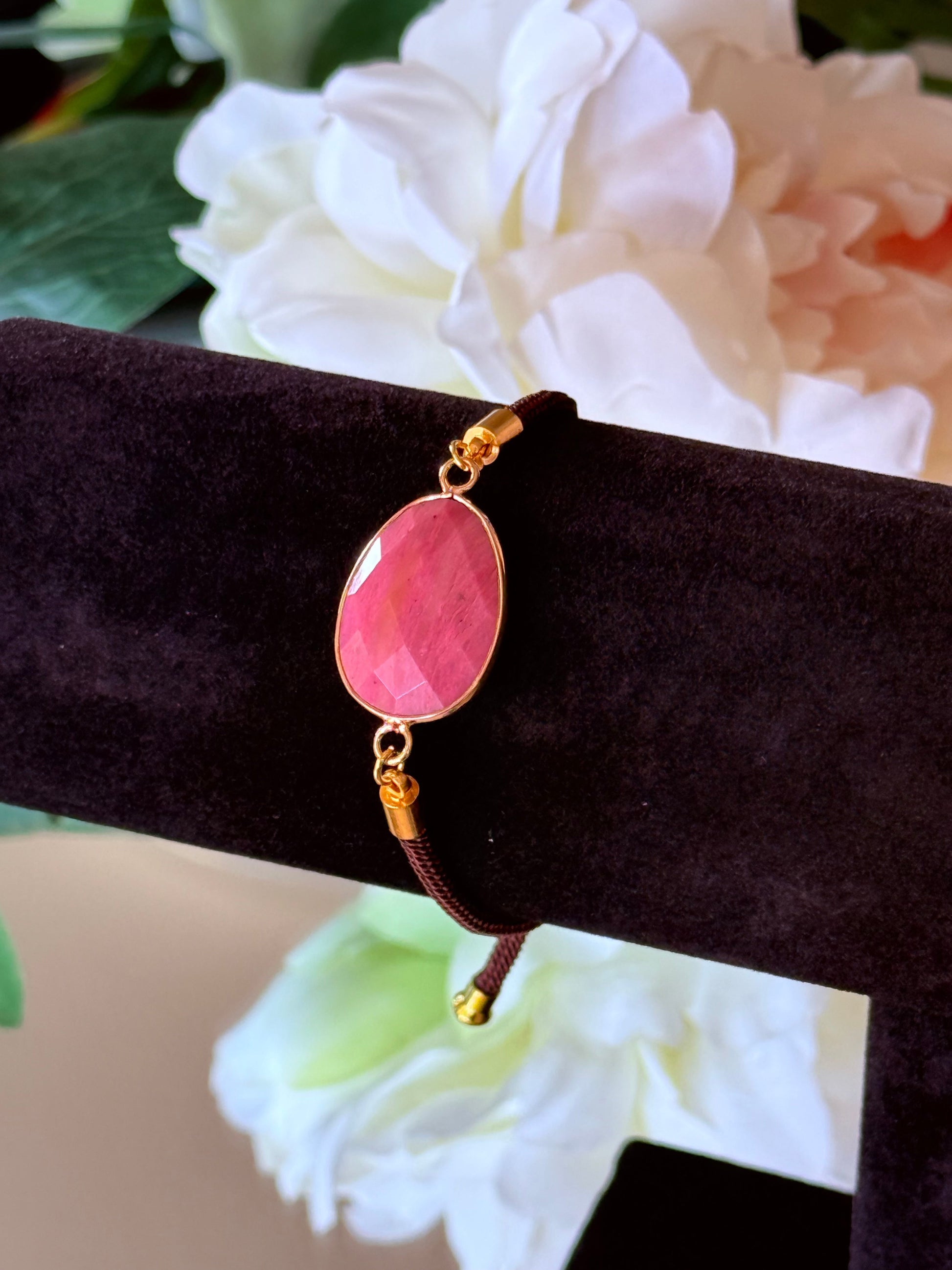 Detailansicht des facettierten Rhodonit Steins (20mm) in goldener Fassung.