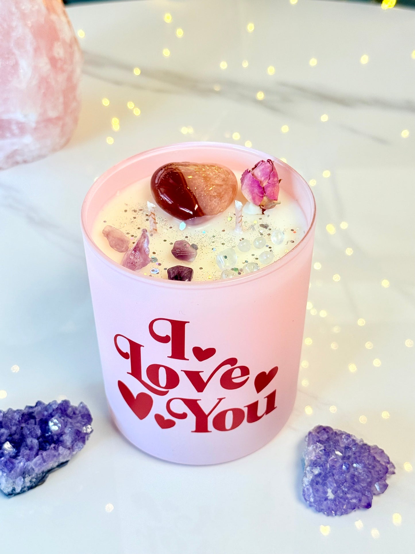 Rosa Kristallkerze mit rotem I Love You Schriftzug, großem Karneol-Herz und Amethyst-Splittern.