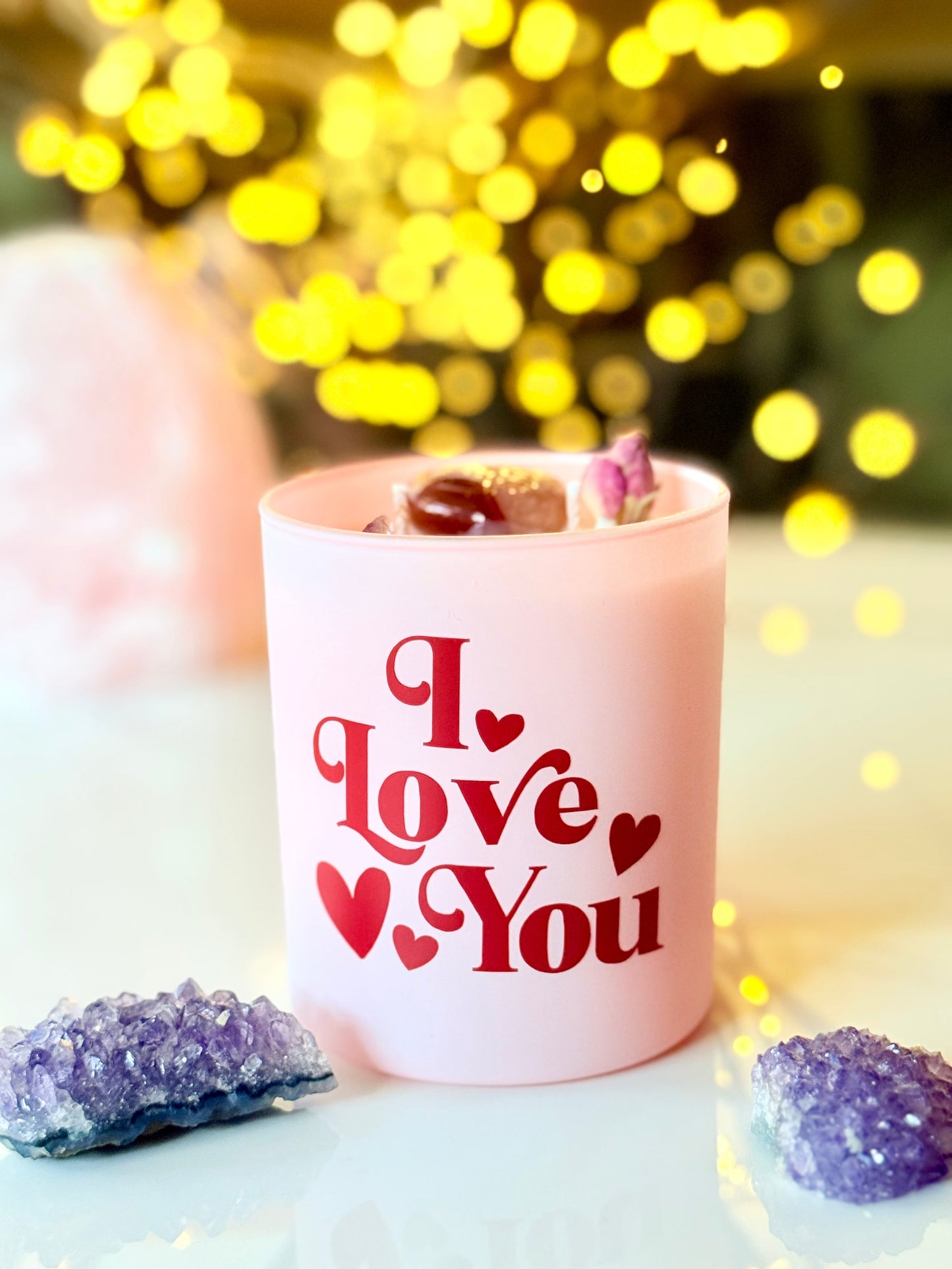 Detailansicht: Poliertes Karneol-Herz und lila Amethyst in einer handgemachten Sojawachskerze.