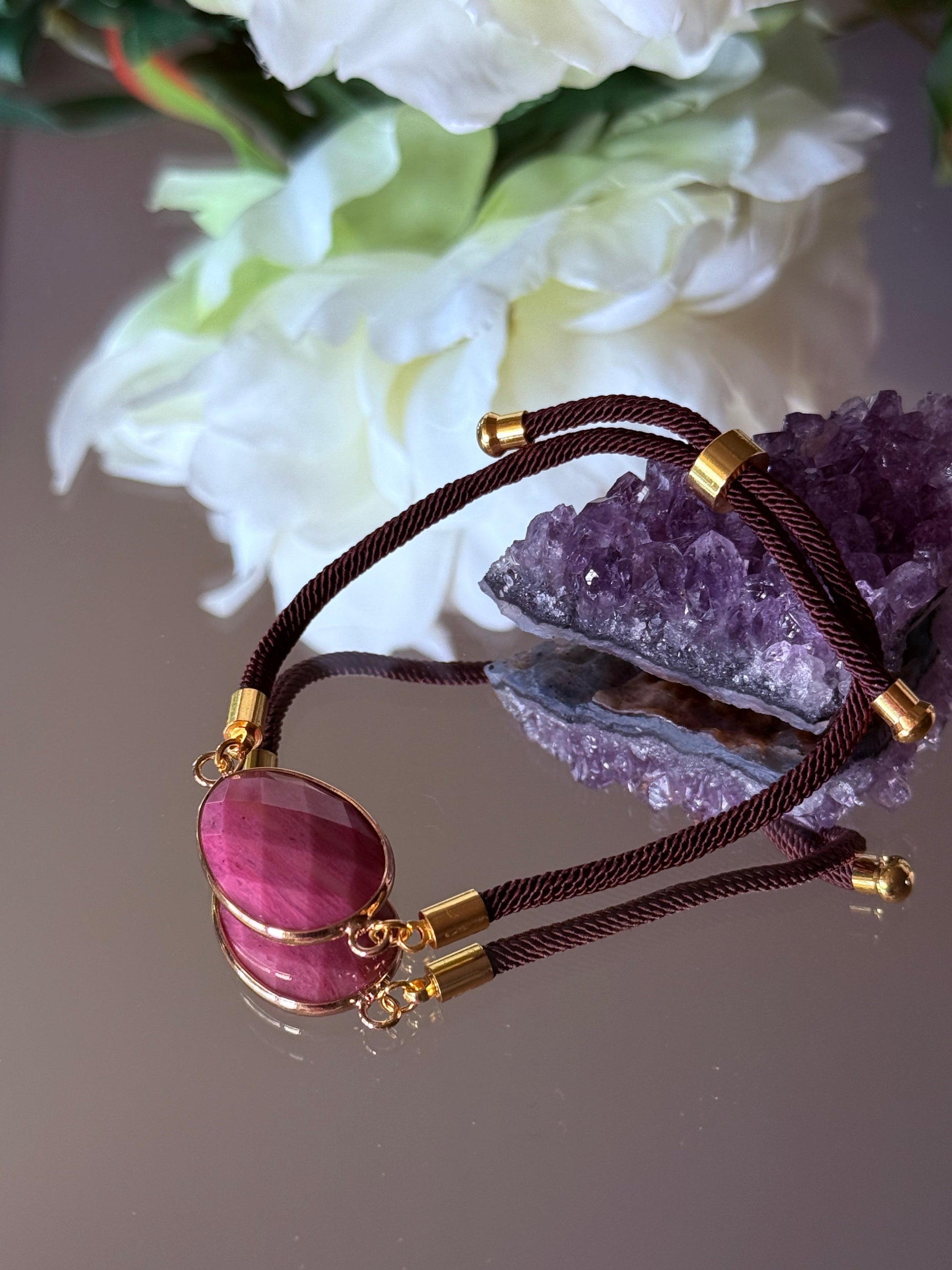 Verstellbares Armband mit rosa Rhodonit Edelstein aus Brasilien und goldenen Details.