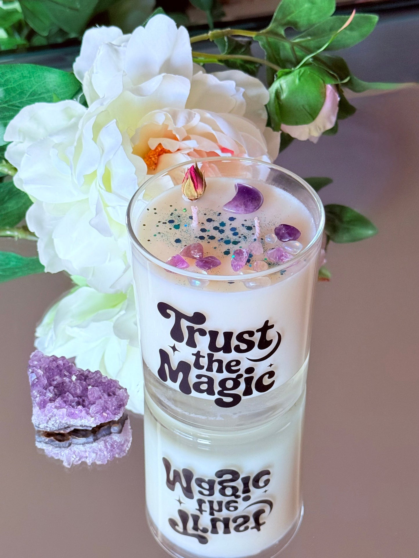 Magische Kristallkerze als spirituelle Dekoration, arrangiert mit einem großen Amethyst-Rohstein im Vordergrund, passend für Ritualarbeit und moderne Hexen-Ästhetik.