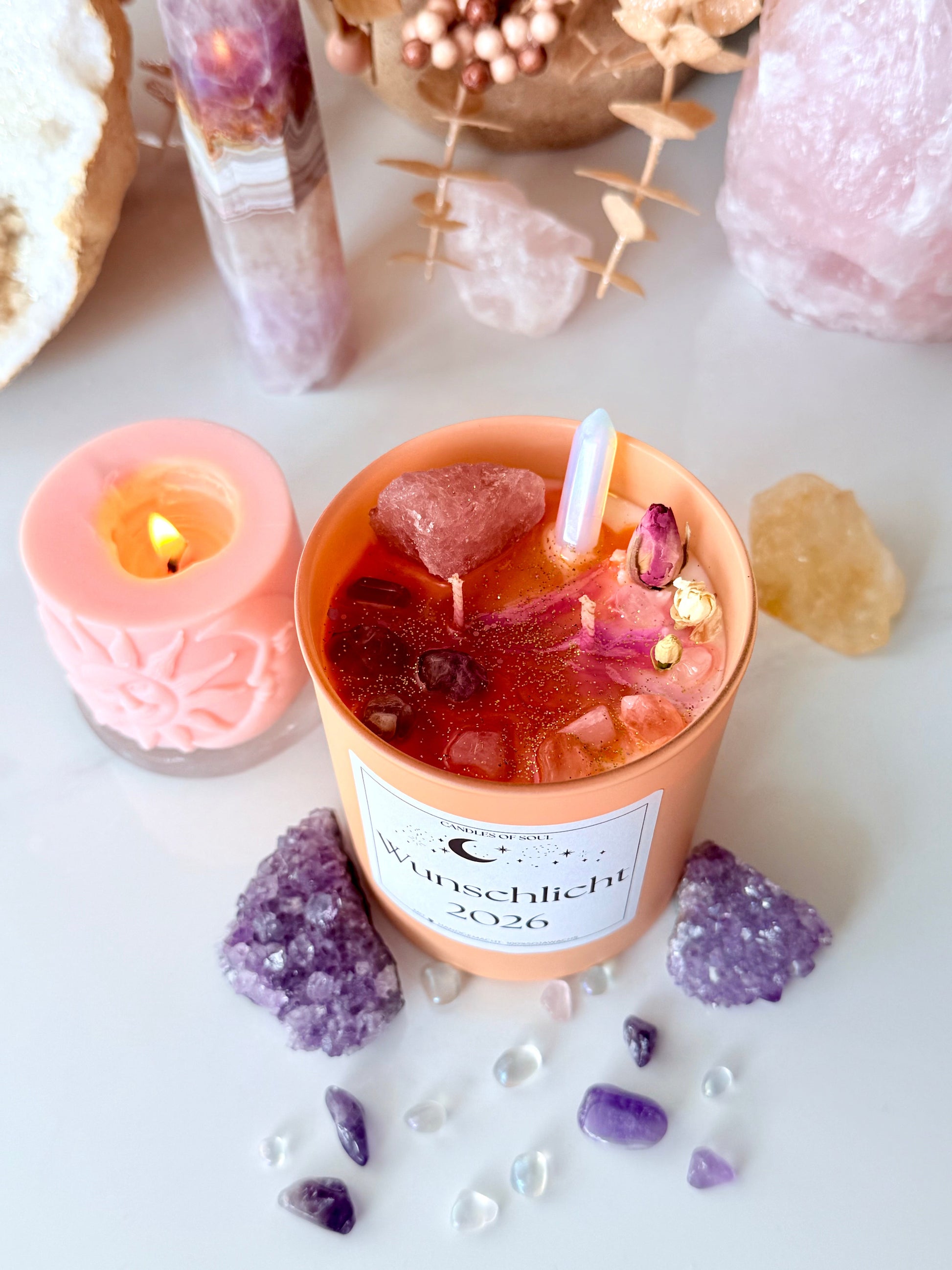 Manifestationskerze aus Sojawachs mit Kristallen in spiritueller Deko-Umgebung.