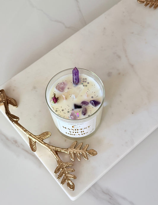 Nahaufnahme einer handgemachten Kristallkerze mit Amethyst-Spitze und getrockneten Rosen