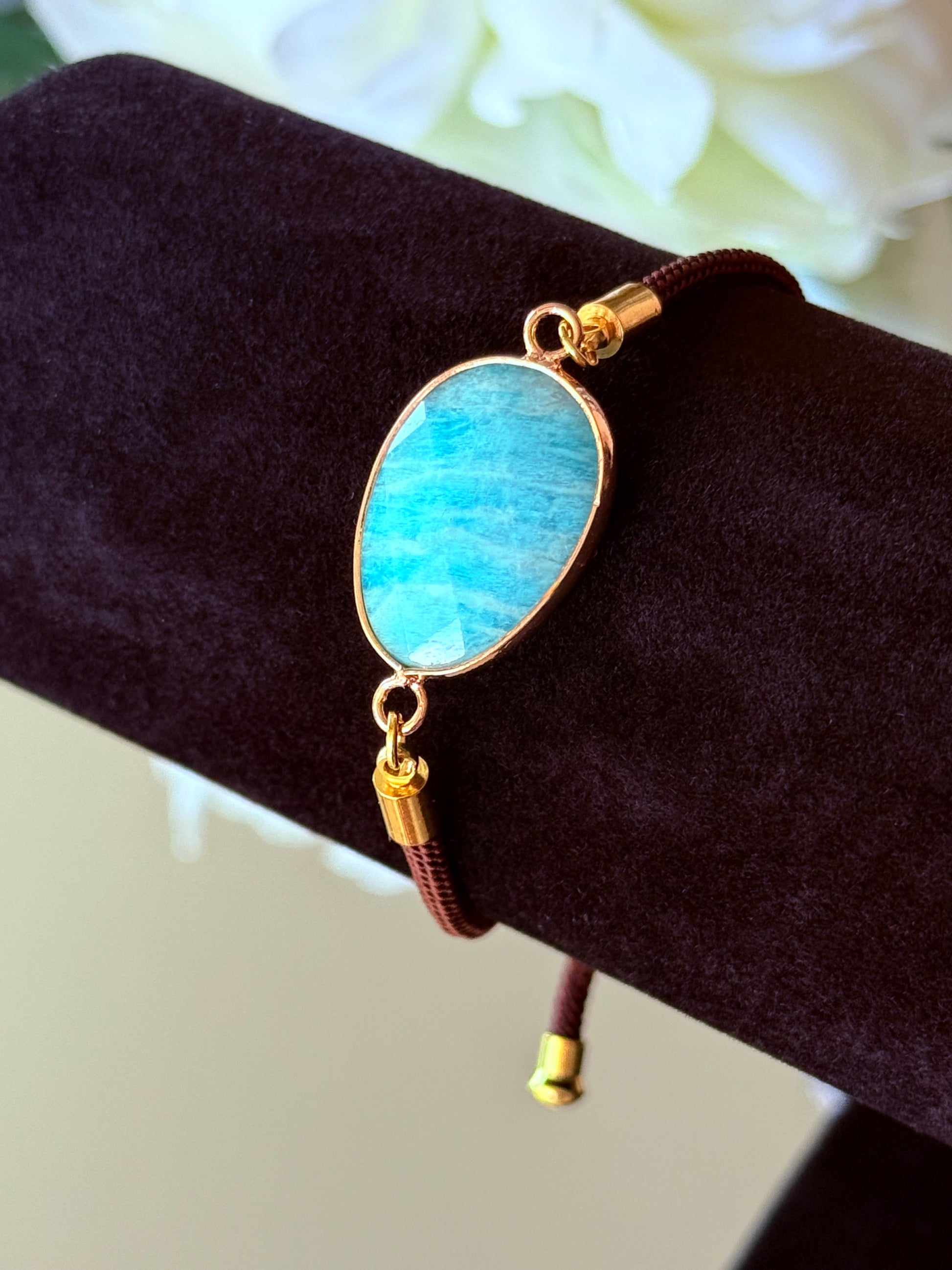 Amazonit Armband für Harmonie und Hoffnung, dekorativ arrangiert auf einem Amethyst-Kristall.