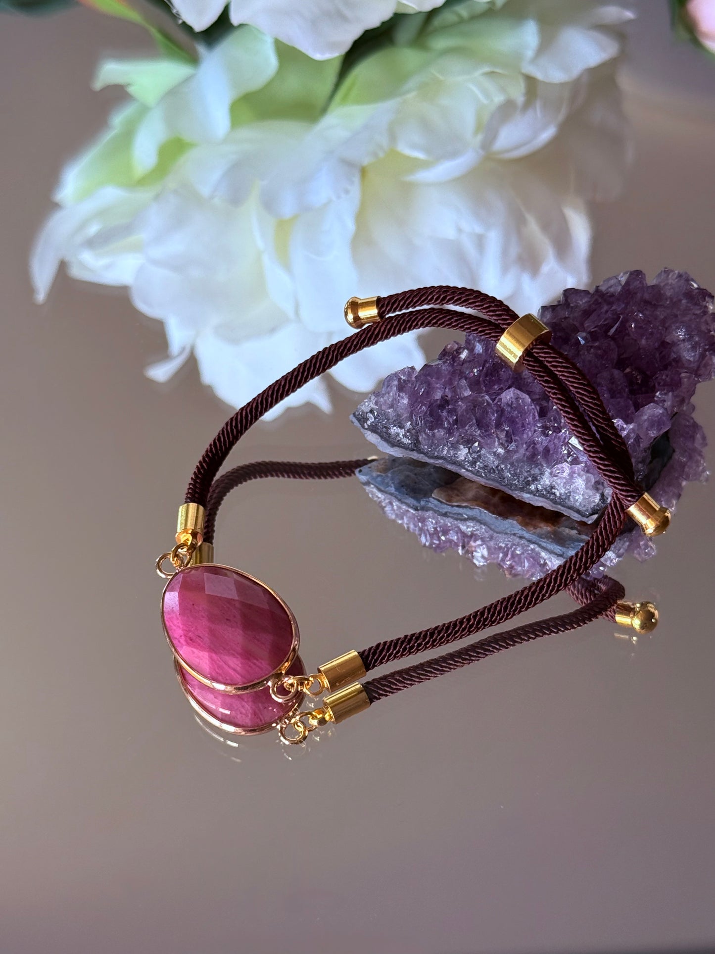 Rhodonit Armband für emotionale Heilung und Herzchakra-Arbeit, dekorativ arrangiert.