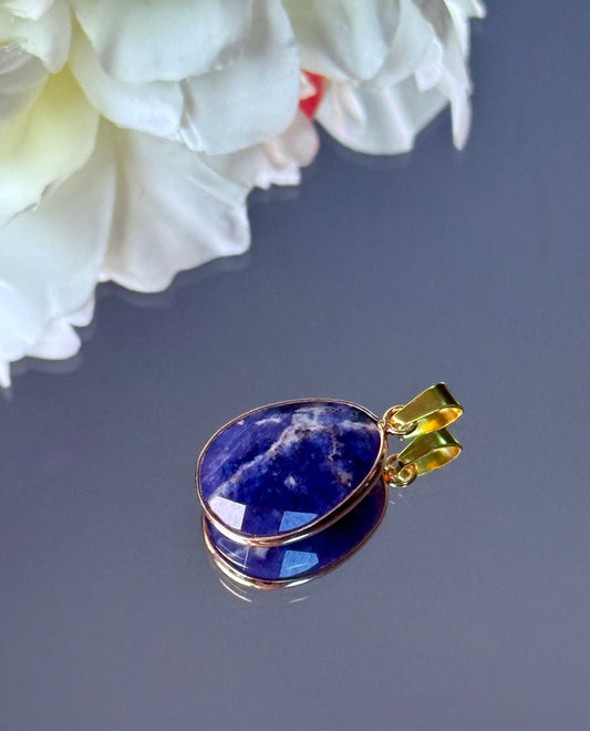 Blauer Sodalith Edelstein Anhänger dekorativ an einer Amethyst-Druse lehnend