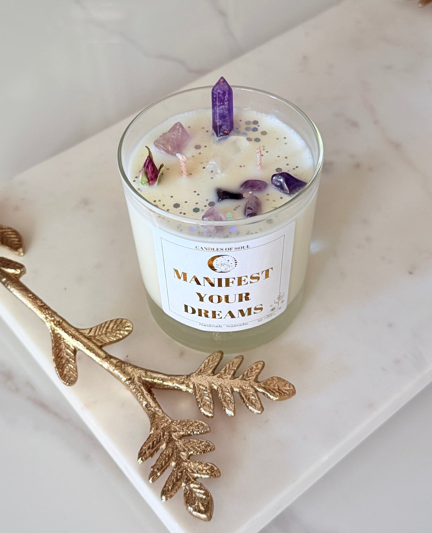 Edle Manifestations-Kerze im Glas mit goldenem Etikett auf einem Spiegeltisch